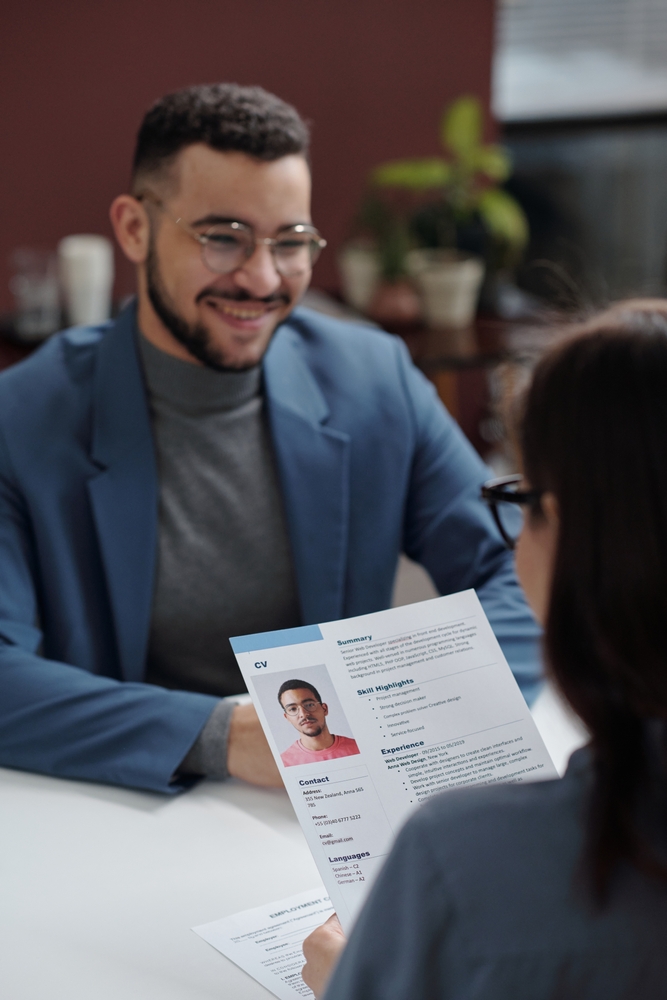 vertical,over,shoulder,view,of,young,hr,manager,reading,cv